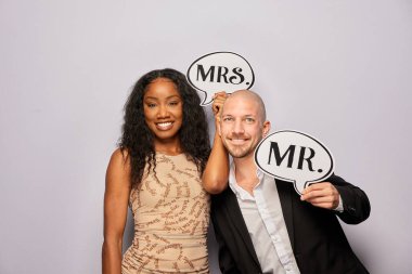 Kadın erkek poz veriyor ve elinde aksesuar var.