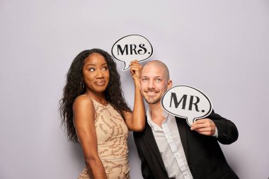 Kadın erkek poz veriyor ve elinde aksesuar var.