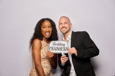 Kadın erkek poz veriyor ve elinde aksesuar var.