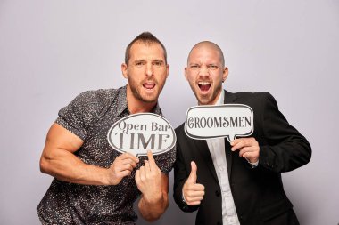 Erkek poz veriyor ve elinde aksesuar var.