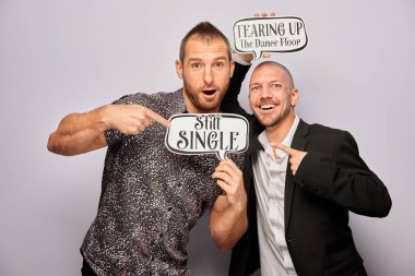 Erkek poz veriyor ve elinde aksesuar var.