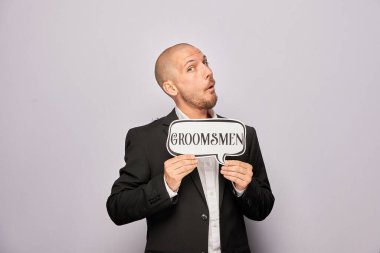 Erkek poz veriyor ve elinde aksesuar var.