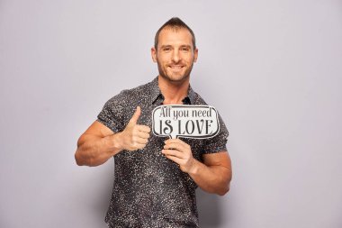 Erkek, fotoğraf kulübesinde poz veriyor.