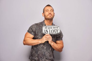 Erkek, fotoğraf kulübesinde poz veriyor.