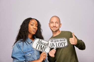 Kadın erkek fotoğraf kabini aksesuarlarıyla poz veriyor