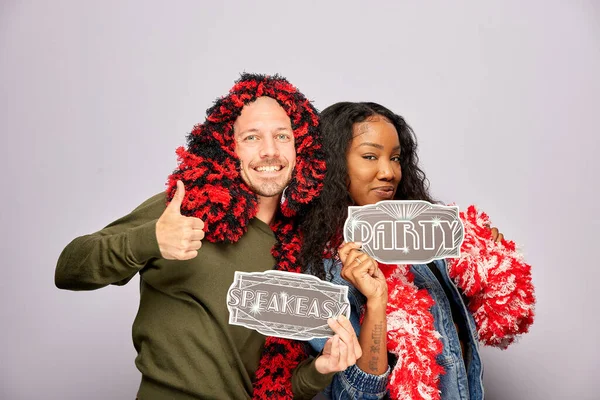 Kadın erkek fotoğraf kabini aksesuarlarıyla poz veriyor