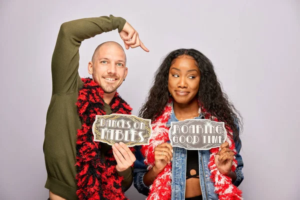 Kadın erkek fotoğraf kabini aksesuarlarıyla poz veriyor