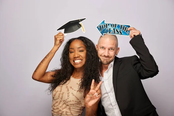 Kadın erkek fotoğraf kabini aksesuarlarıyla poz veriyor