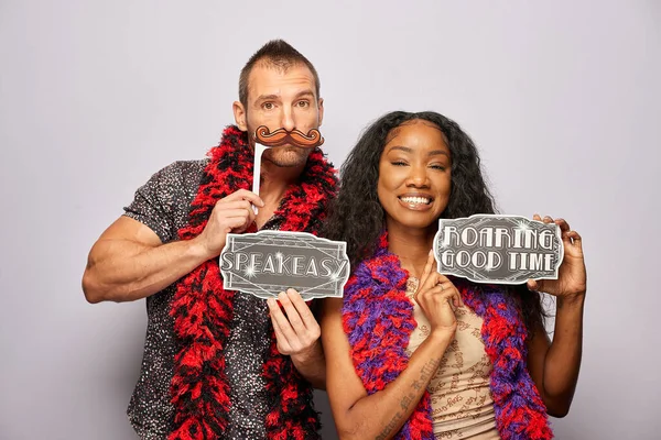 Kadın erkek fotoğraf kabini aksesuarlarıyla poz veriyor