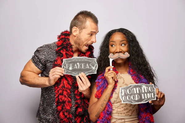 Kadın erkek fotoğraf kabini aksesuarlarıyla poz veriyor