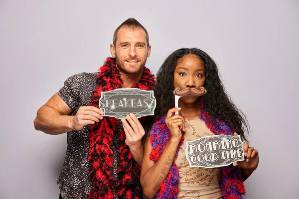 Kadın erkek fotoğraf kabini aksesuarlarıyla poz veriyor