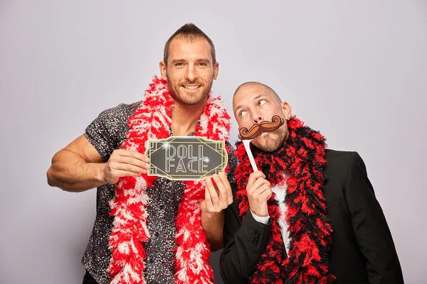 Erkek poz veriyor ve elinde aksesuar var.