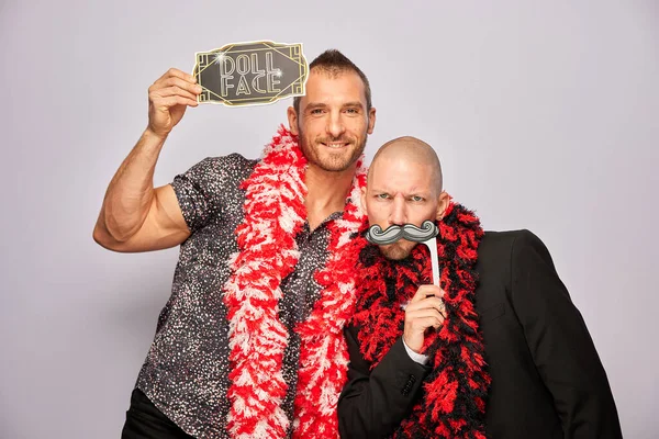 Erkek poz veriyor ve elinde aksesuar var.