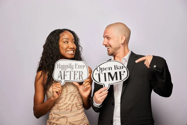 Kadın erkek poz veriyor ve elinde aksesuar var.