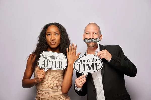 Kadın erkek poz veriyor ve elinde aksesuar var.