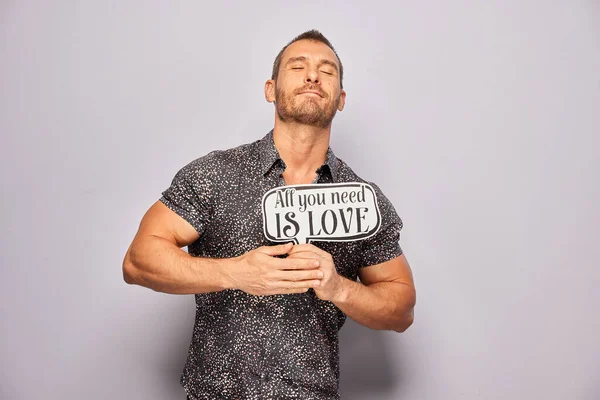 Erkek, fotoğraf kulübesinde poz veriyor.