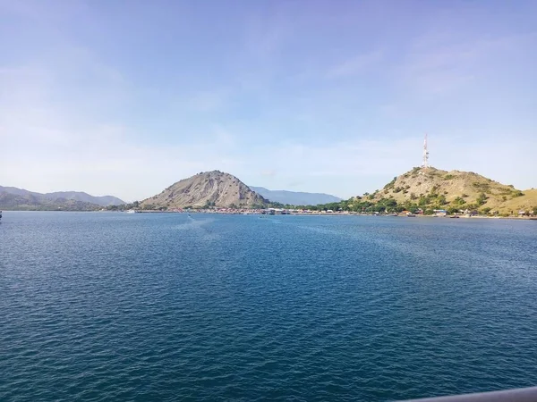Tano sumbawa limanındaki iskelenin yakınındaki dağın illüstrasyon fotoğrafı.