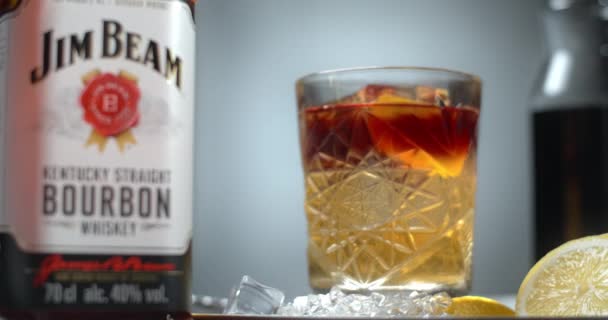 WAARSCHUWING, POLEN - SEPTEMBER 10, 2021: Focus trek van de cocktail naar de fles Jim Beam bourbon drink, 4k 60p Prores HQ — Stockvideo