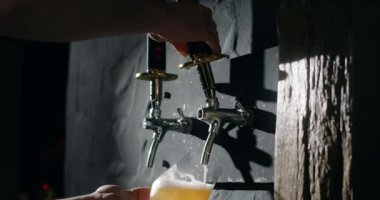 Barmen bira musluğundan bardağa kadar filtrelenmemiş hafif birayı yavaş çekimde doldurur, birahaneye buğday birası döker, 4k 120 fps Prores HQ