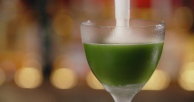 Barmen kokteyle tatlı aromalı çırpılmış yumurta ekliyor. Yavaş çekimde beyaz, barmen tezgahta kokteyl yapıyor. 4k 120 fps Prores HQ.