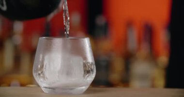 Bar tezgahındaki buzlu bardağa köpüklü şarap dökülüyor. Yavaş çekimde 4k 120 fps Prores HQ.