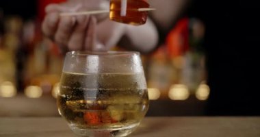 Barmen kokteyl bardağına marmelat ekliyor, bu da barın tezgahındaki kokteyli, 4k Prores 120 fp yapıyor.