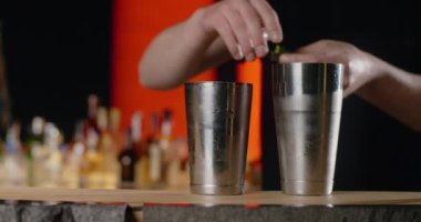 Barmen açılışa taze shiso yaprağı ekliyor, karışımı perilla otuyla yapıyor, barmen tezgahta soğuk içecekleri karıştırıyor, 4k 120 fps Prores HQ