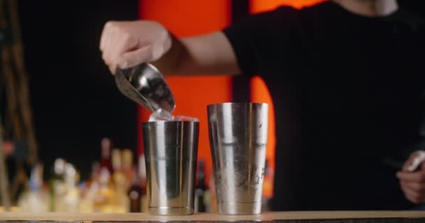 Barman adds ice cubes to the shaker in slow motion, bartender mixes cocktails on the bar counter, 4k 120 fps Prores HQ — Stock Video