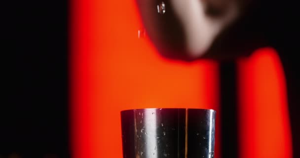 Κοντινό πλάνο: μπάρμαν ρίχνει μέρος του διαφανούς αλκοόλ στο σέικερ σε αργή κίνηση, κάνοντας το κοκτέιλ στον πάγκο μπαρ, 4k Prores HQ 120 fps — Αρχείο Βίντεο
