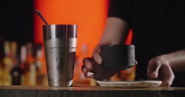 Бармен кладет большой кубик льда на замороженный коктейль глины кружку пинцетом, делая коктейль в барной стойке, 4k Прорес HQ — стоковое видео