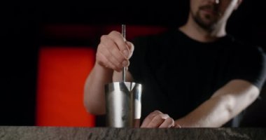 Barmen yavaşça barın tezgahındaki karıştırıcıyı karıştırır, gece kulübündeki alkollü içecek, 4k Prores 120fps