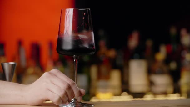 Barman rotates glss with red wine in slow motion, sommelier mixing red wine in glass evaluating color at tasting, winemaking concept, Full Hd 240 fps Prores HQ — Stock Video