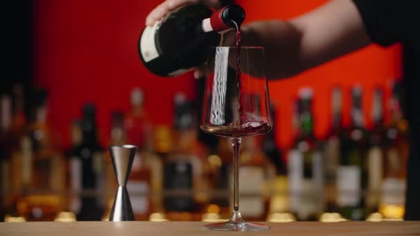 Barman wlewa czerwone wino do kieliszka do wina przy barze w zwolnionym tempie, Full HD 240 fps Prores HQ — Wideo stockowe