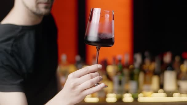 Sommelier rotates the glass of wine in hands slow motion and mixing red wine in glass evaluating color at tasting, winemaking concept, Full Hd 240 fps Prores HQ — Stock Video