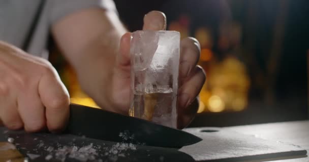 Barmen büyük buz küpünden keskin bıçakla ezilmiş buz yapar, kokteyli tezgahın üzerinde yapar, soğuk içecekler tazeler, 4k Prores Karargahı 120fps — Stok video