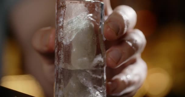 Barista rende ghiaccio tritato da grande cubetto di ghiaccio con coltello affilato, rendendo il cocktail sul bancone del bar, bevande fredde rinfrescanti, 4k Prores HQ 120fps — Video Stock