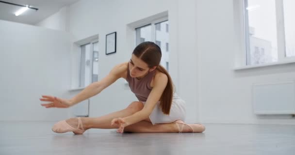 Bailarina está no ensaio da escola de balé, coreógrafo ensaios no salão de dança branca, bailarina aquece, a dança de arte em câmera lenta, 4k DCI 60p Prores HQ 10 bit — Vídeo de Stock