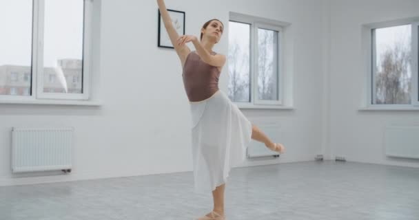 Ballerina is op de balletschool repetitie, choreograaf repeteert in de witte danszaal, ballerina warmt op, de kunstdans in slow motion, 4k 60p Prores HQ 10 bit — Stockvideo