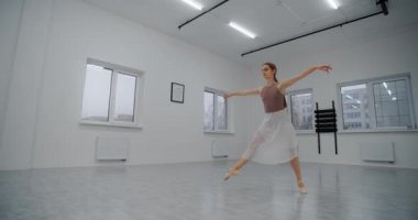 Sivri uçlu ayakkabılı balerin dans odasında koşar ve yavaş çekimde birkaç kez zıplar, dans eder ve havada sicim sallar, akrobatik dans eder, 4k 120 fps Prores Karargahı 10 bit