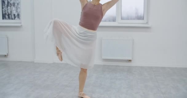 Ballerina ist bei der Ballettschulprobe, Choreografin probt im weißen Tanzsaal, anmutiger Kunsttanz in Zeitlupe, 4k 60p Prores HQ 10 bit — Stockvideo