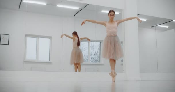 Balerina tańczy na końcach swoich szpiczastych butów przy ścianie lustra, kobieta tańczy na palcach, ćwiczy na lekcji baletu, ćwiczy taniec, 4k DCI 60p Prores HQ — Wideo stockowe