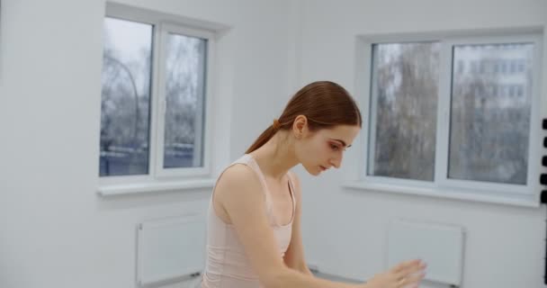 Bailarina está no ensaio da escola de balé, coreógrafo ensaios no salão de dança branca, dança de arte graciosa em câmera lenta, 4k 60p Prores HQ 10 bit — Vídeo de Stock