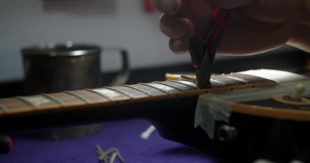 Recusando a guitarra, luthier substitui trastes na guitarra elétrica, loja de instrumentos musicais de reparação, 4k 60fps Prores HQ — Vídeo de Stock