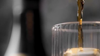 Kokteyl bardağındaki büyük buz küpüne alkol döküldü. Viski viskiler viskilere döküldü. Full HD 240 fps Prores karargahlarına.