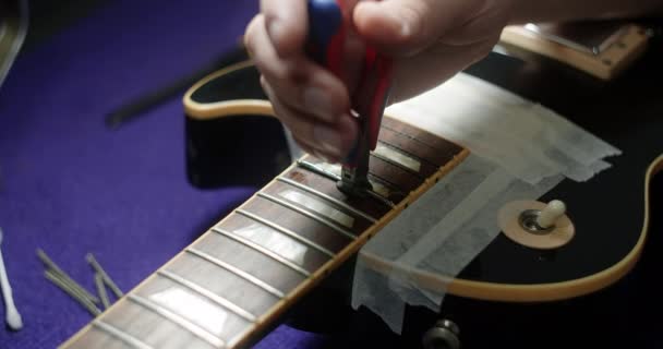 Recusando a guitarra, luthier substitui trastes na guitarra elétrica, loja de instrumentos musicais de reparação, 4k 60fps Prores HQ — Vídeo de Stock