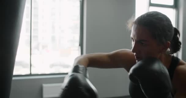 Kickboxer donna in guantoni da boxe pugni sacco boxer al rallentatore, allenamento nel club di boxe, 4k 60p Prores HQ — Video Stock