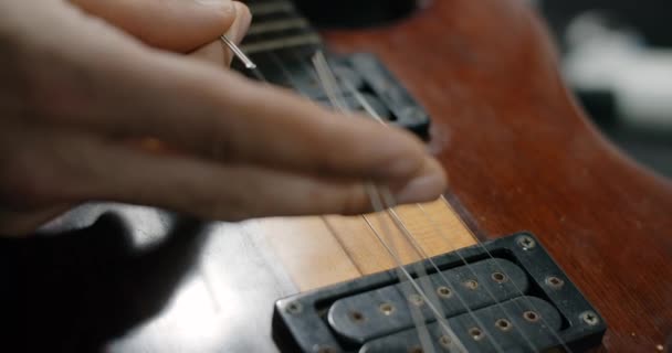 Guitar tech coupe les cordes de la guitare par des pinces au ralenti, changeant les cordes de la guitare électrique, 4k 60p 10 bits — Video