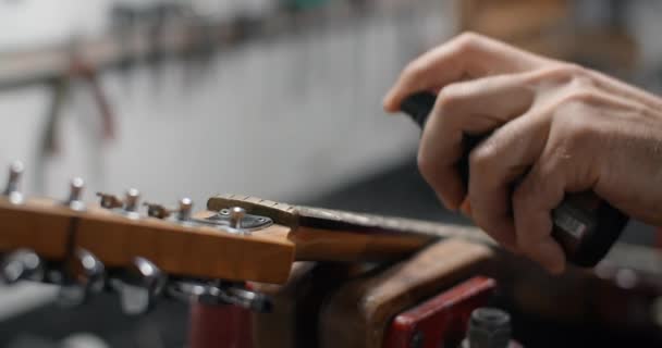 吉他技术人员慢动作地在吉他颈、吉他服务商店、 4k 60p 10位喷砂板清洁剂 — 图库视频影像