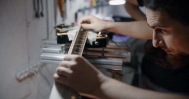 Luthier jig üzerinde elektro gitar yaka fretboard açısını ölçer, dükkandaki müzik aletlerini tamir eder, 4k 60p 10 bit