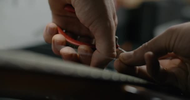 Guitar tech cuts the strings on the guitar by nippers in slow motion, changing the strings on the electric guitar, 4k 60p 10 bit — Stock Video